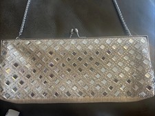 gold evening bag with long silver colored chain . Snap closure .