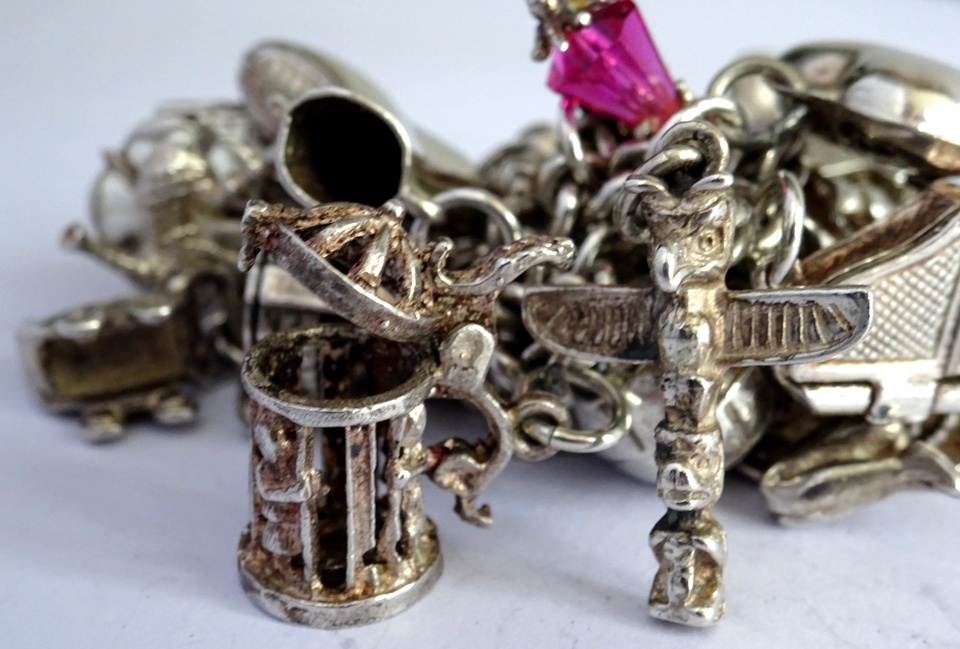 Vintage heavy solid silver charm bracelet &many curious silver charms ...