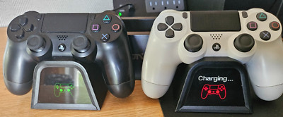 TWO (2) PS4 PLAYSTATION CONTROLLERS with OIVO MULTIFUNCTIONAL COOLING STATION