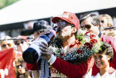 Bobby Rahal 1st position celebrates with a large bottle of B Indy 1986 Photo