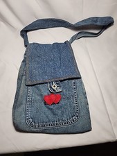 This is a handmade denim crossbody bag with red heart appliques.