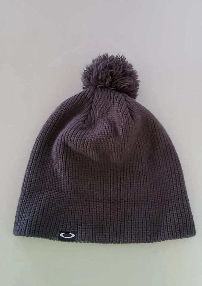 Gorra de invierno Oakley Pom Pom tejida gris talla única para la mayoría de las mujeres logotipo "O" usada en excelente estado Foto 2 de 4