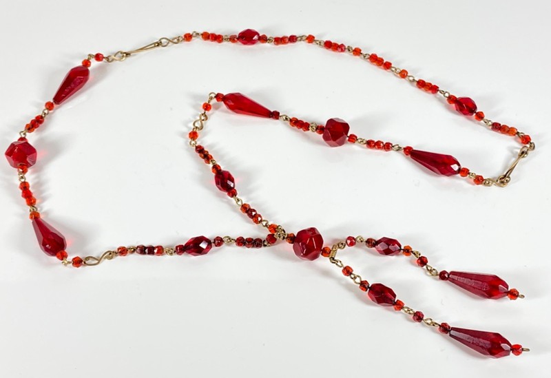 This 26" (approximately) red glass bead vintage gold tone (brass tone) necklace 
