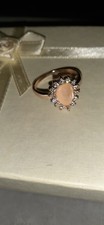 rose gold-plated cluster ring with a round white opal center stone and a rhinest