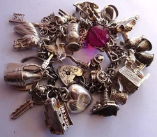 Vintage heavy solid silver charm bracelet &many curious silver charms inc moving