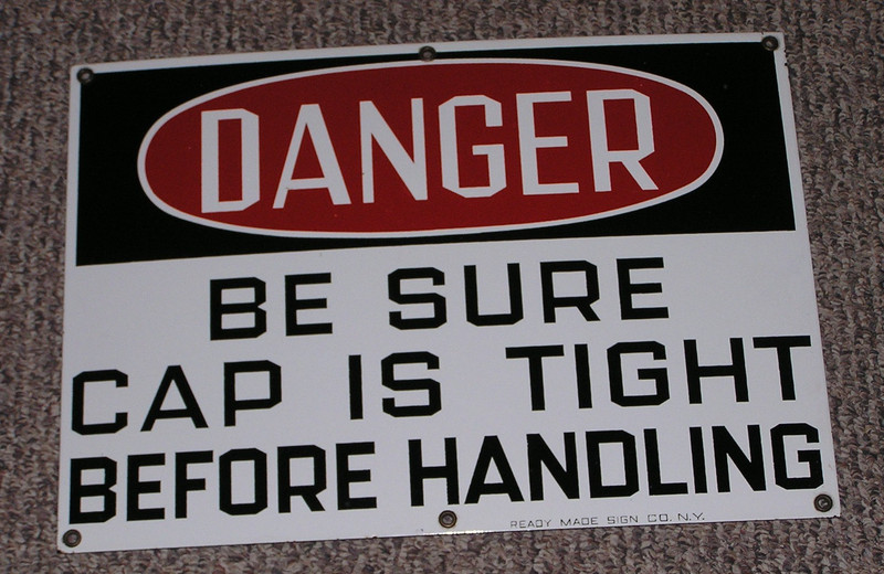 porcelain sign DANGER BE SURE CAP IS TIGHT BEFORE HANDLING looks new unused