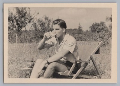 Junger Mann trinkt Milch im Klappstuhl - Altes Foto 1950er
