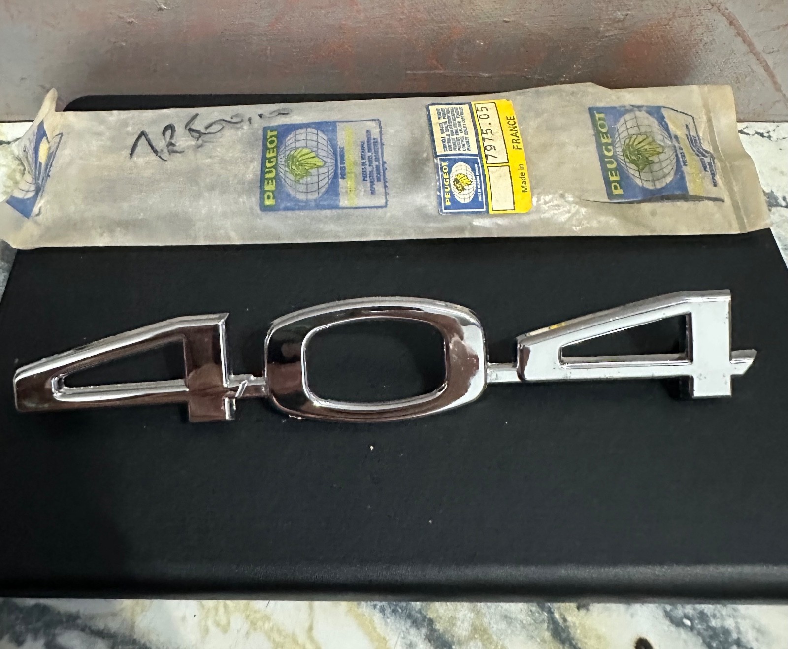 Monogramme de capot Peugeot 404 neuf pièce d'origine vintage chrome impeccable