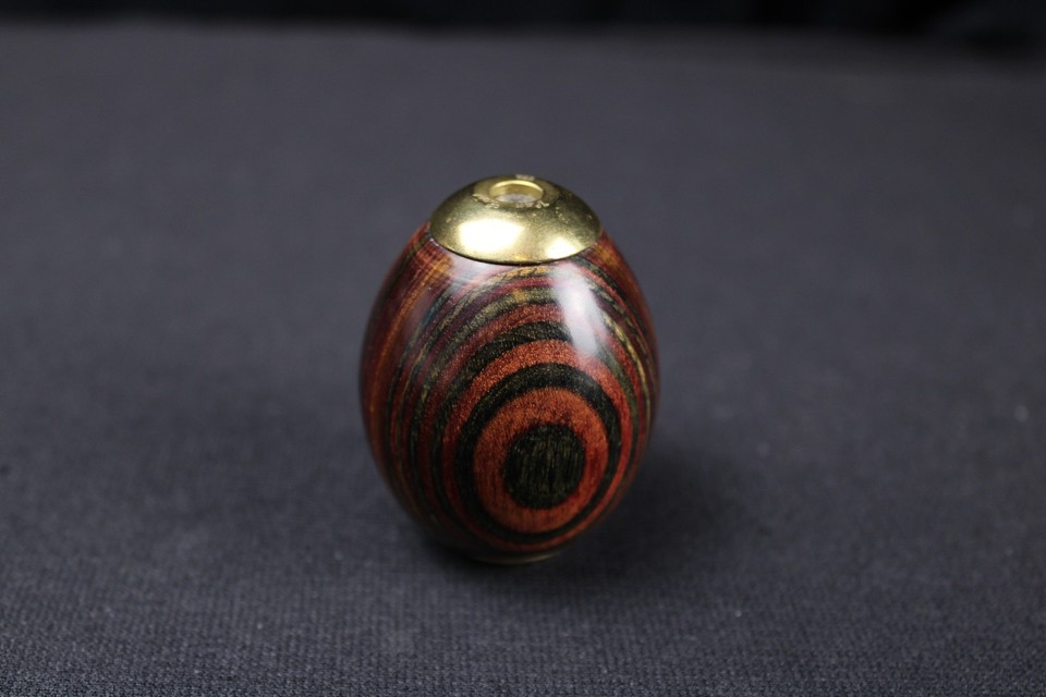 A hand-carved wooden egg that unfolds into a brass kaleidoscope — tactile, optical, and genuinely enchanting.