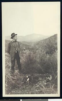 Man standing next to a pine sapling California Old Photo