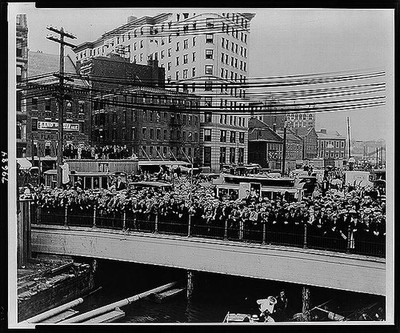 Crowd on bridge, rooftop, etc. to watch performance of Harry Houdini,