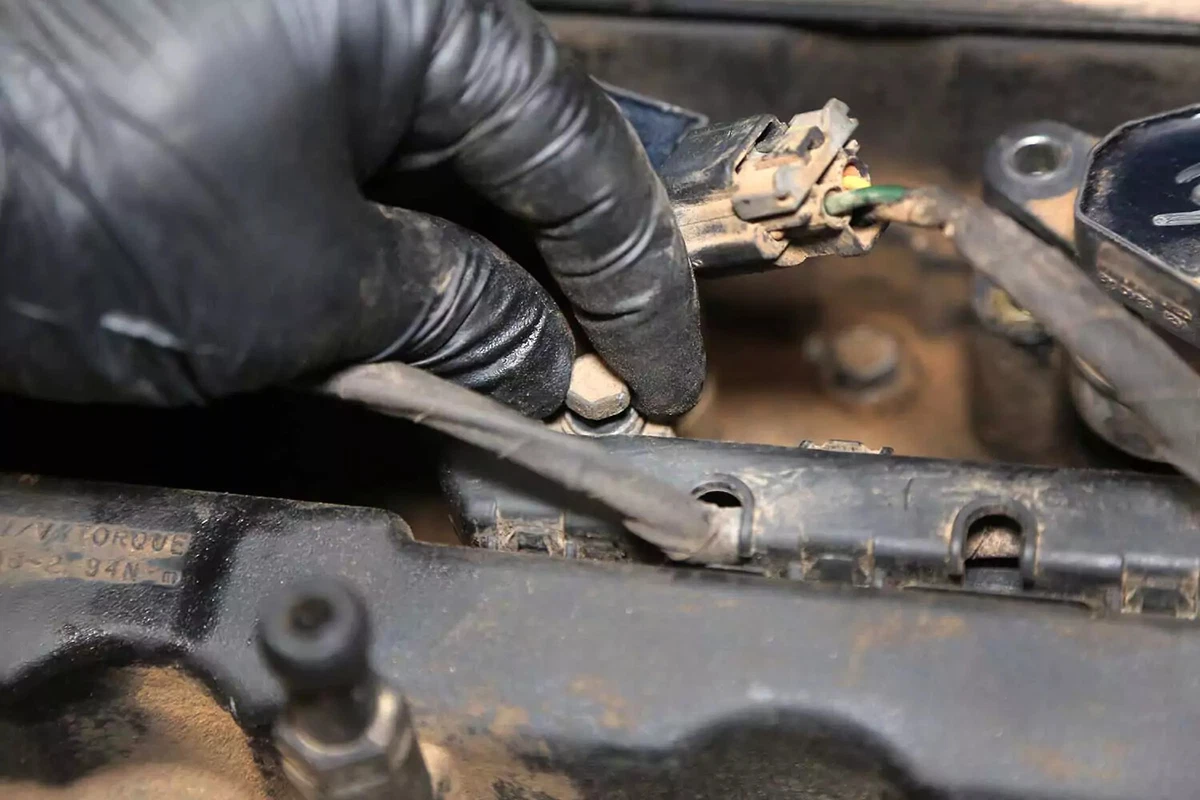 Removing a wiring harness bolt.