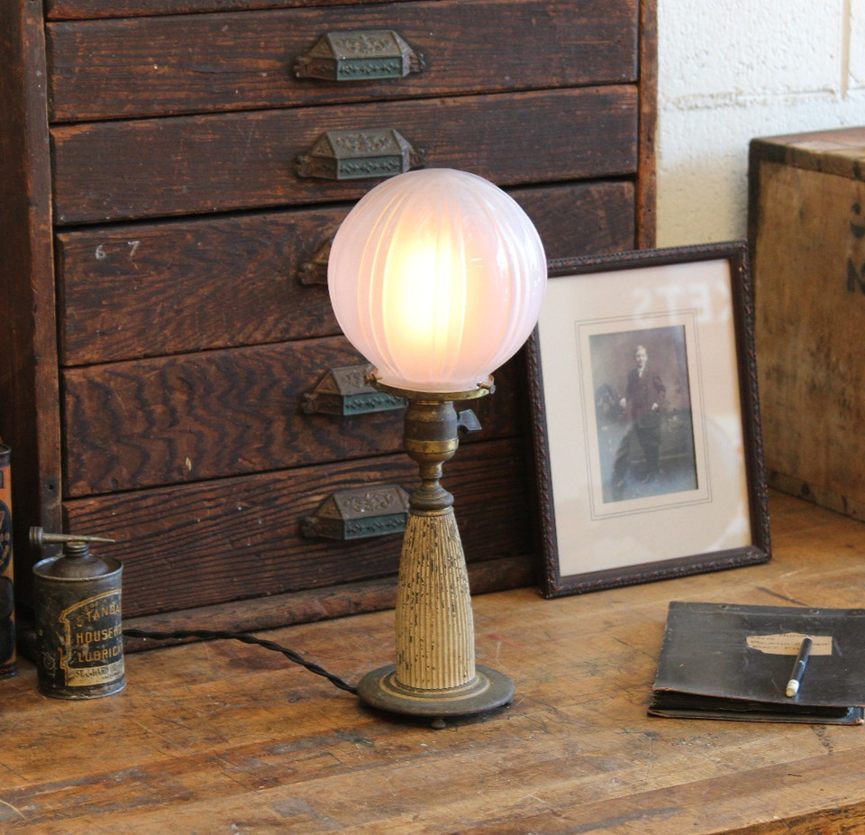A genuine Art Deco industrial brass desk lamp with a glass globe — the kind of one-of-a-kind vintage find that defines a room.
