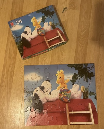 Vintage MB Puzzle Peanuts 24-piece box with Snoopy and Woodstock in a red-covered doghouse, surrounded by green trees.
