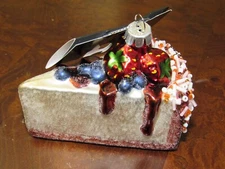 Glass Christmas ornament, slice of cake with blueberries and strawberries.