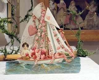 Cherubino bidimensionale naviga un veliero decorato con cuore. Germania anni '30