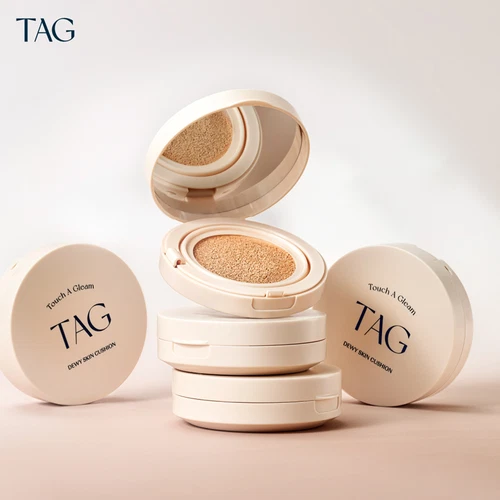 Two beige TAG Dewy Skin Cushion 15g SPF50+ with PA+++, each in open box showing tan cushion and black text.