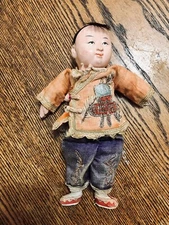 ANTIQUE COMPOSITION CHINESE DOLL IN EMBROIDERED SILK CLOTHING.