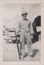 WW2 Photo of Helmeted Soldier Holding Rifle Beside Desert Tent Camp