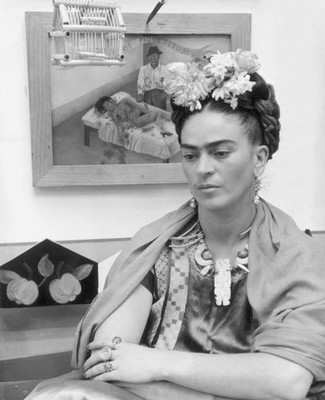 Mexican painter Frida Kahlo sits with her arms folded looking down - Old Photo