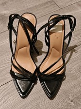 Black, strappy, pointed-toe high-heeled sandals with stiletto heel and ankle tie
