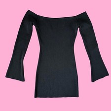 Off-shoulder black crepe knit mini dress with flared sleeves.