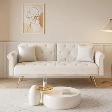 A 69.7-inch-long sofa bed covered in beige velvet fabric, featuring nail head tr