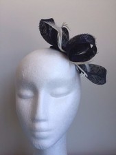 Navy blue sinamay loop fascinator with white feathers on a clear comb