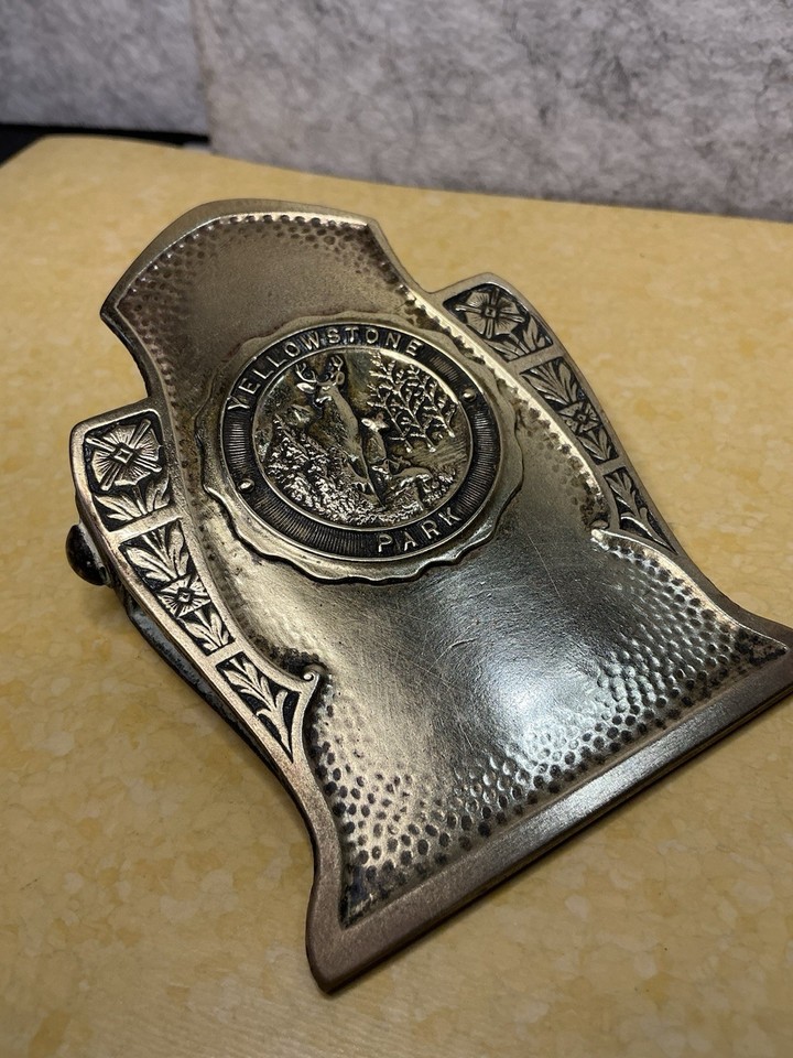An Art Nouveau brass binder clip from Robbins Co. with a Yellowstone Park souvenir engraving — impossibly specific, historically rich, and absolutely one-of-a-kind.