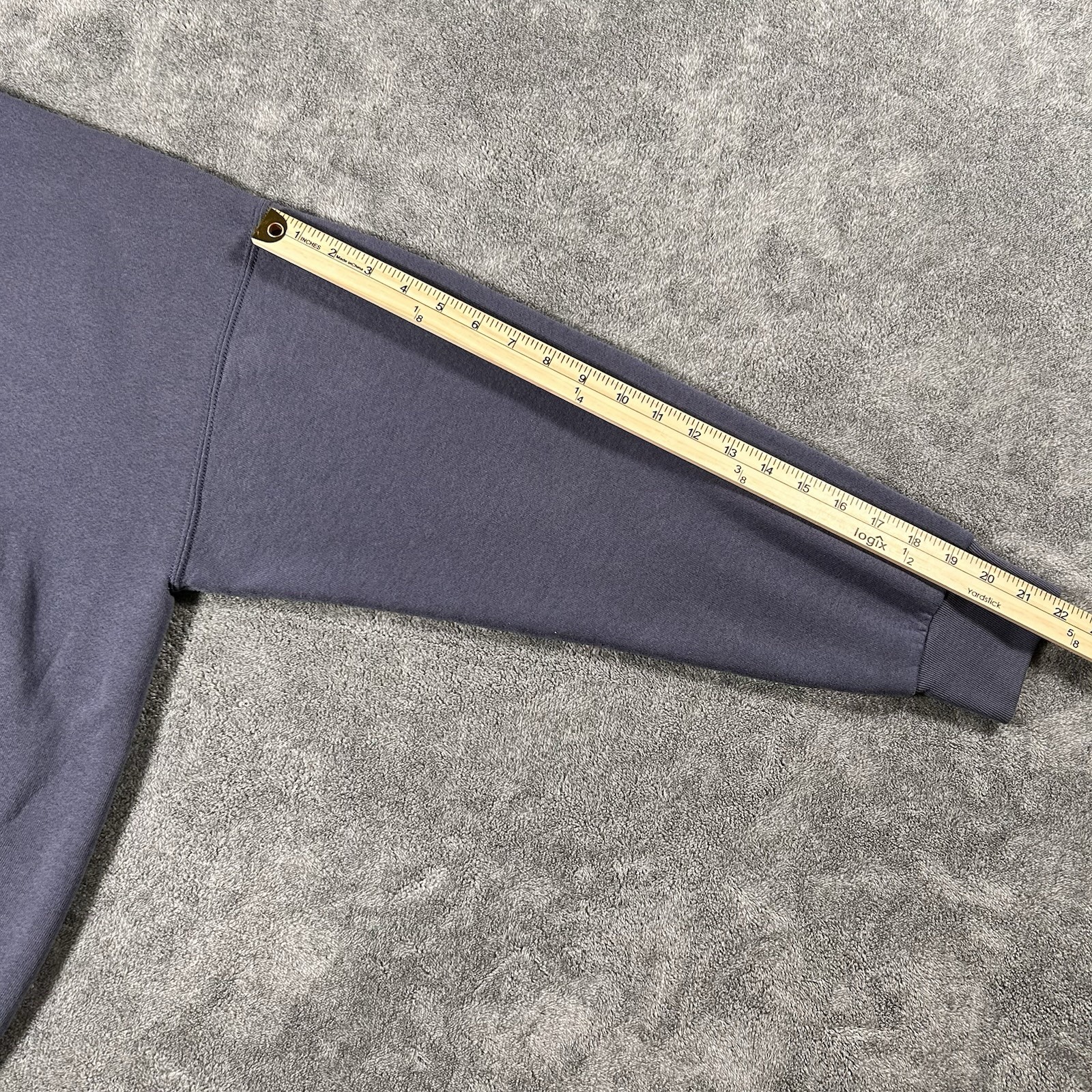 Gray Calvin Klein jeans sweatshirt with long sleeves, yellow measuring tape along the left sleeve.