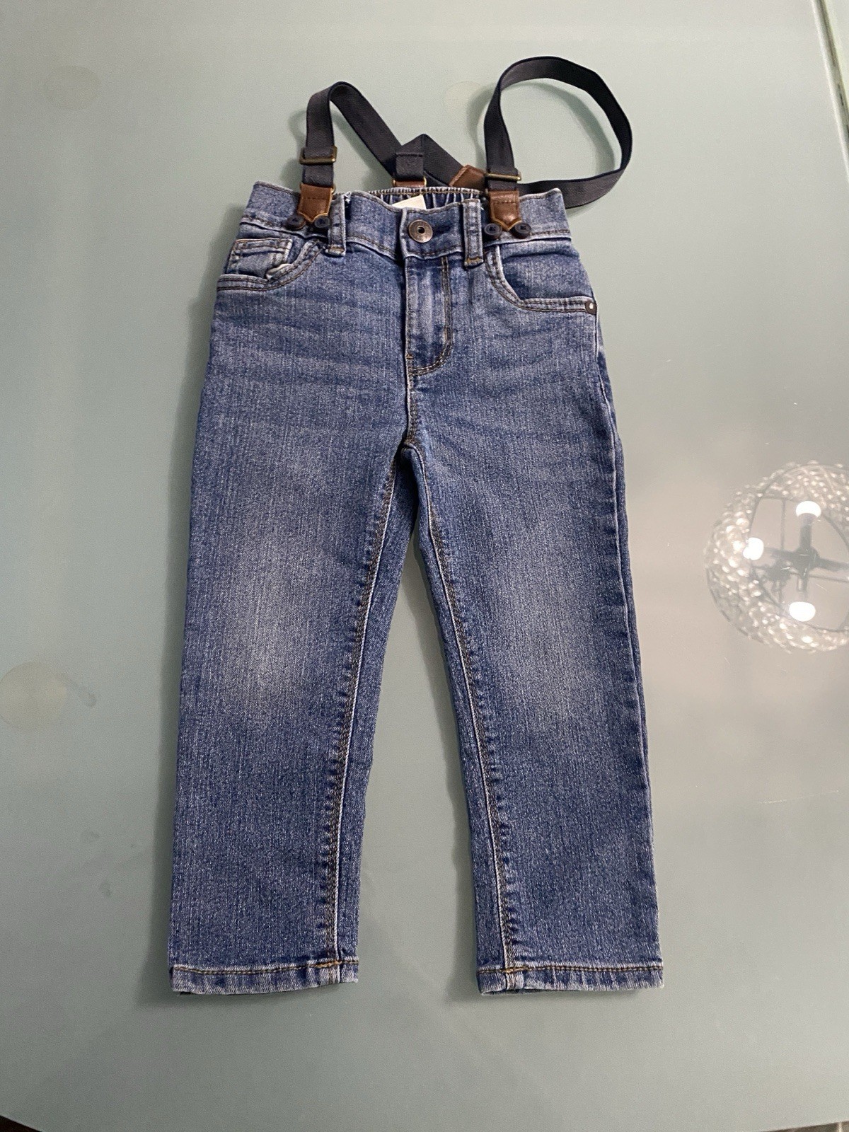 OshKosh B'gosh blue denim toddler jeans featuring detachable black suspenders