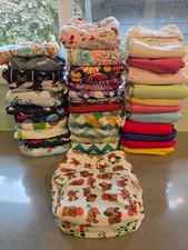 35 Multi brand cloth diapers lot, with extra inserts and wet bags.