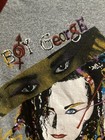 Gray long-sleeve shirt with “Boy George” text, yellow-red graphic, and blue-black eyes on front.