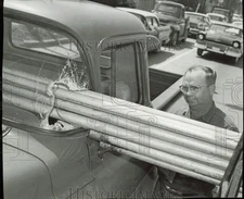 1959 Press Photo Claude Harman inspects pipe which speared his pickup truck, TX