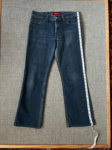 Dark wash 1990s Levi’s Superlow 518 bootcut jeans, waist 31, with yellow measuring tape along the length.