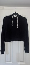 Women's black cropped hoodie featuring long sleeves and white drawstrings