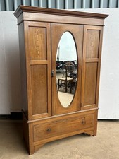 A Mahogany and inlaid wardrobe with oval mirror door