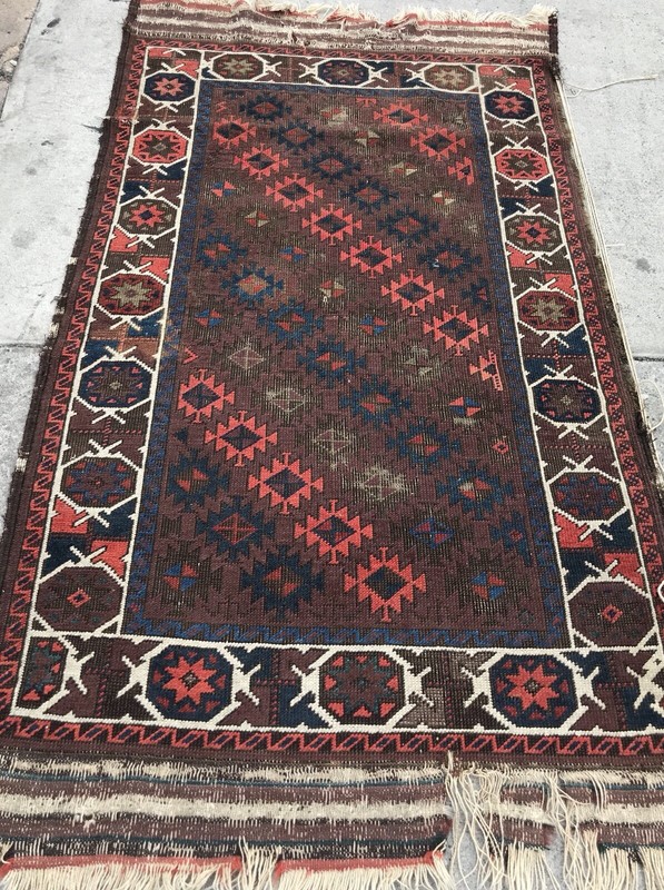 AN ANTIQUE BALUCHSTAN TRIBAL RUG