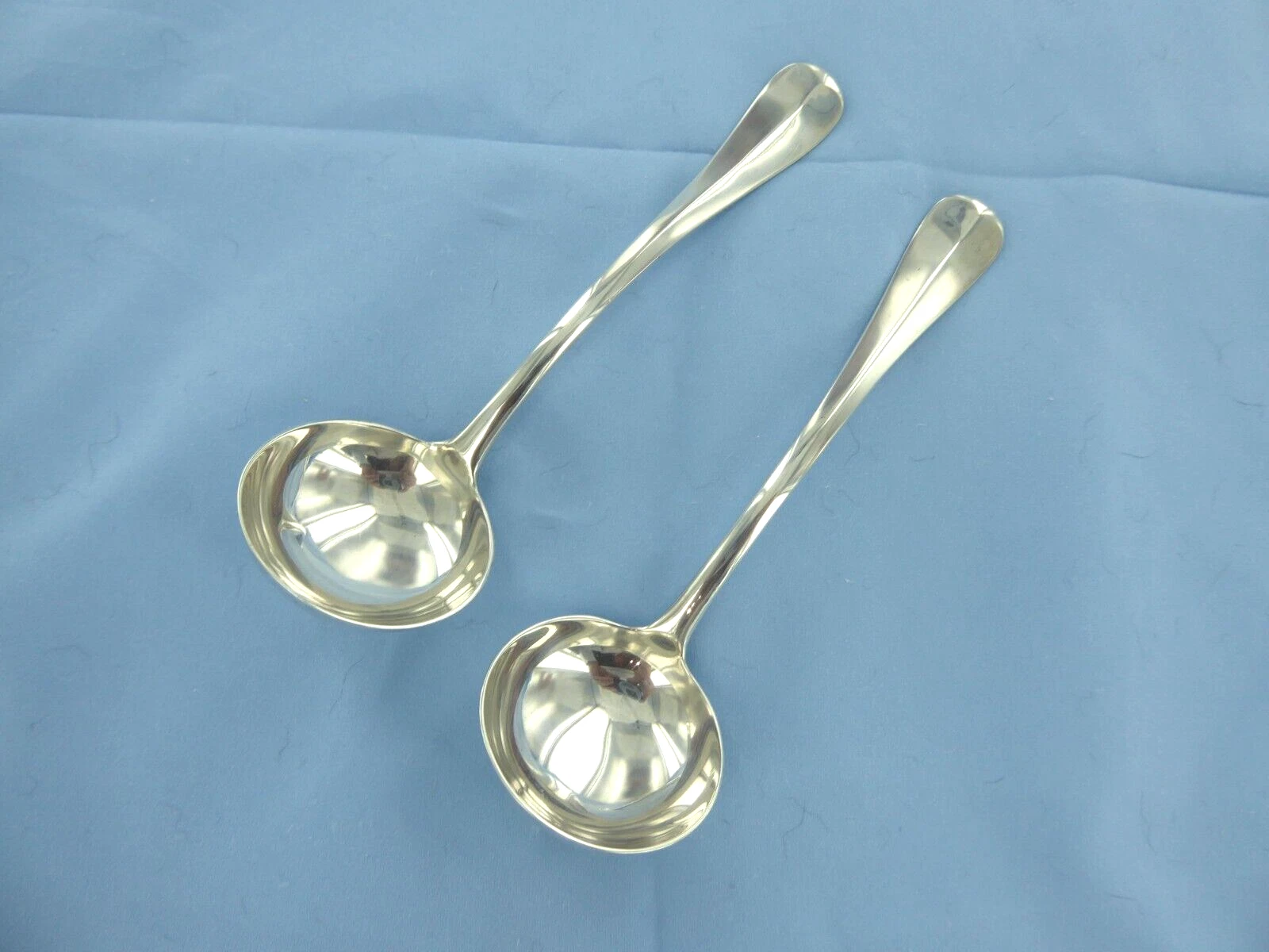 A VINTAGE PAIR OF STERLING SILVER OLD ENGLISH RAT TAIL SAUCE LADLES,LONDON 1929.
Opens in a new wind