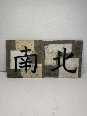 Asian-style wall plaques feature calligraphy characters for ''South'' and ''North