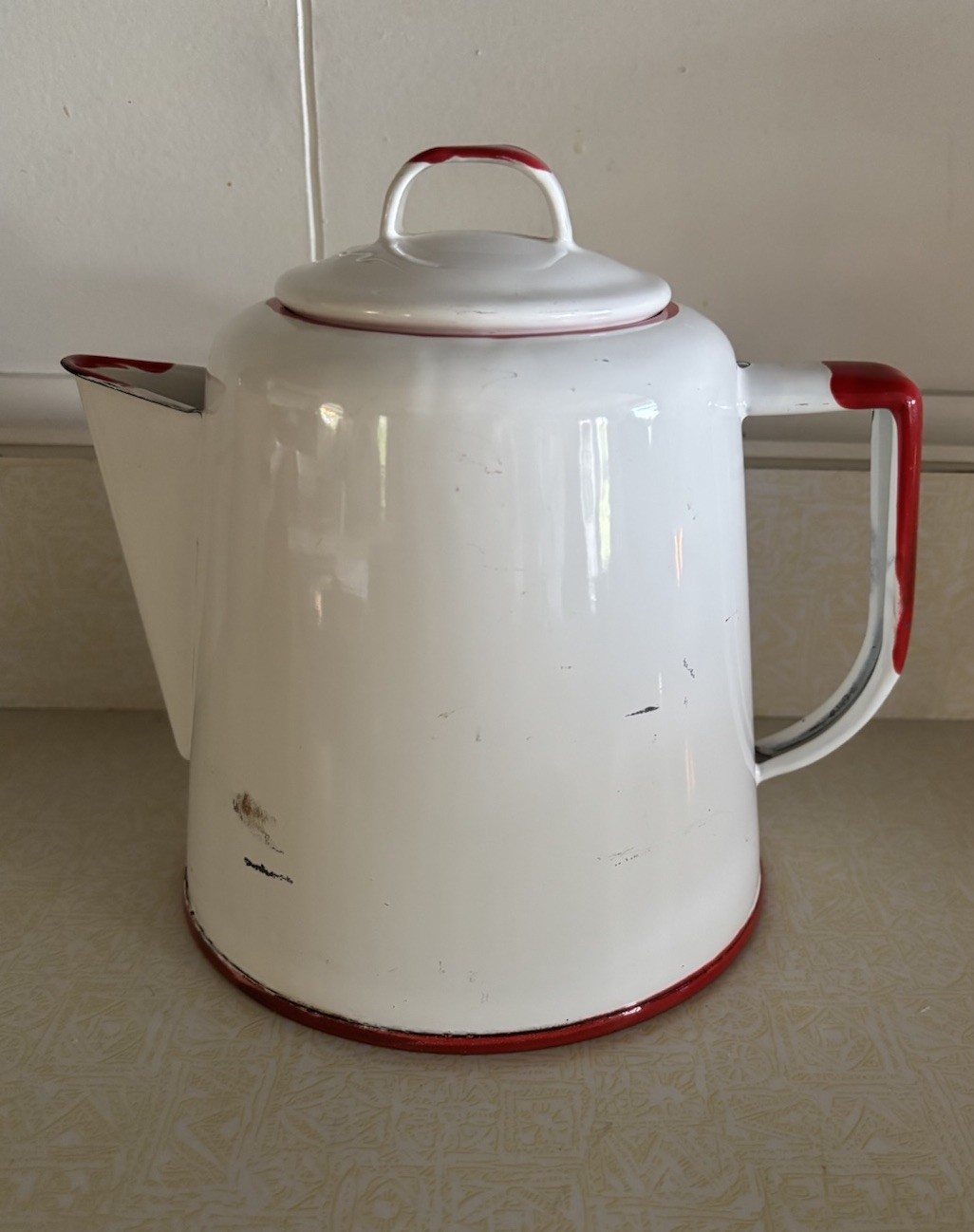 Small red and white enamelware kettle coffee pot with lid.