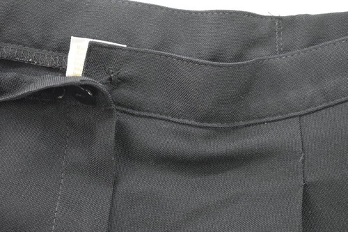 Black Jantzen women’s pants with front button closure, pleated detailing, and white size 12 tag on waistband.