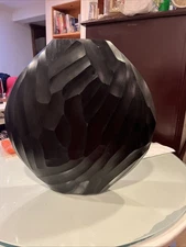 decorative, dark-colored object with a textured, faceted surface.