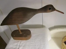 Primitive bird on stick and piece of wood.