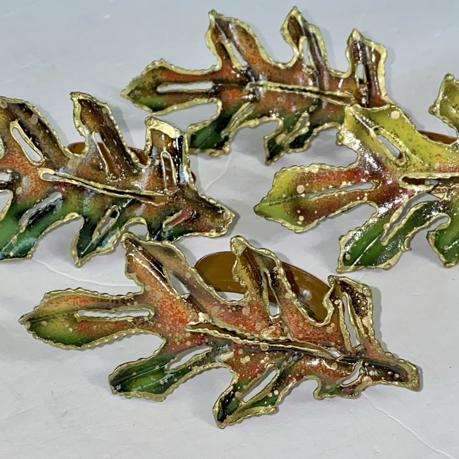 Set of four metal napkin rings shaped like oak leaves