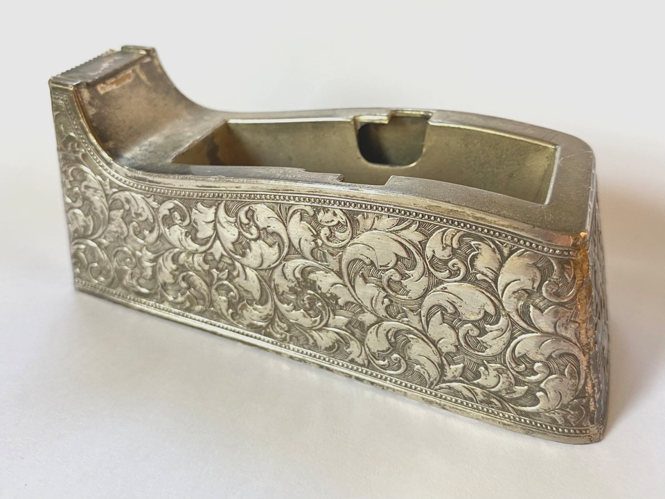 An Eleanor Claire silver-plate tape dispenser with embossed detailing — the kind of glamorous desk accessory that makes Scotch tape feel luxurious.