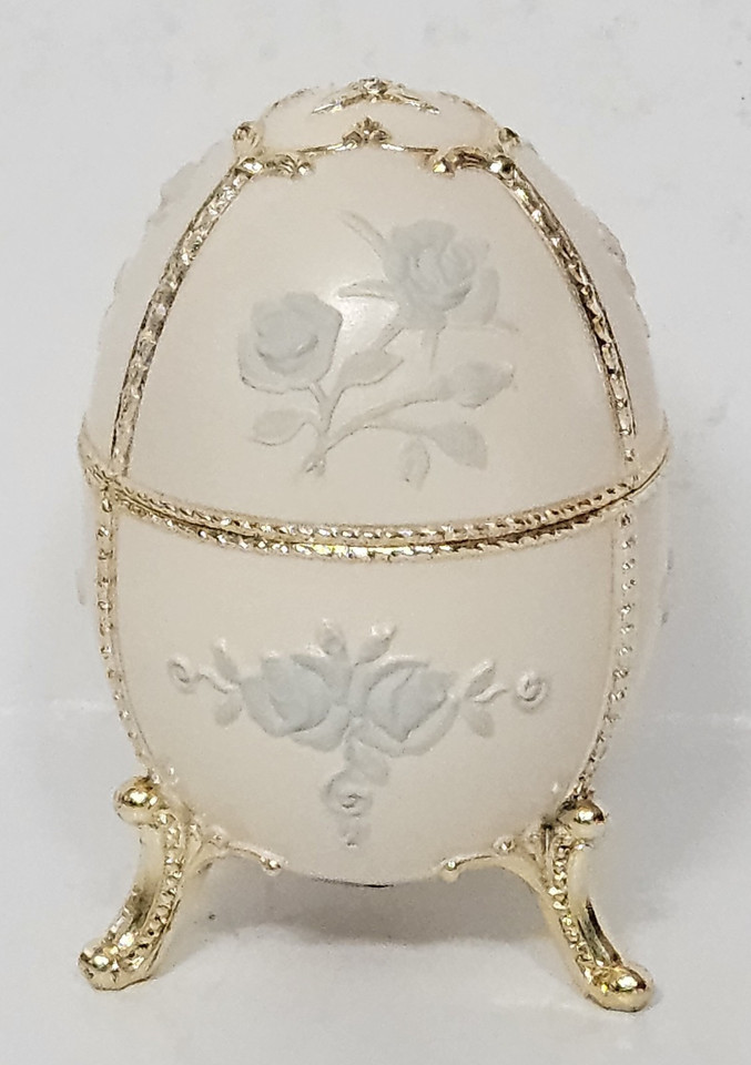 Egg-shaped cream music box with hand-painted blue roses from Sankyo — a classic Japanese maker known for silky-smooth movements.
