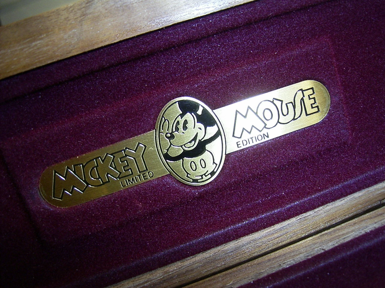 Gold pen with black “Mickey Mouse Edition” text and sterling silver barrel on dark burgundy fabric.