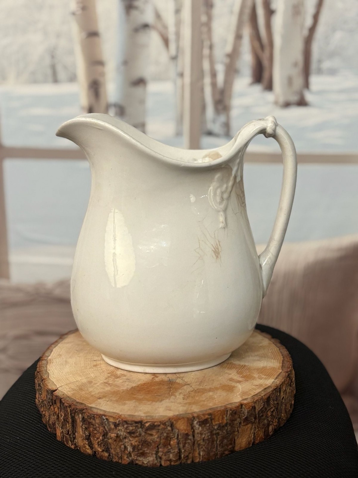 Antique white ironstone pitcher with a classic bulbous body.