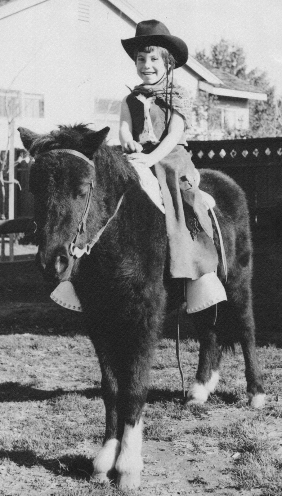 Cappello cowboy ragazza su pony anni 50 sorridente cortile momento infanzia felice